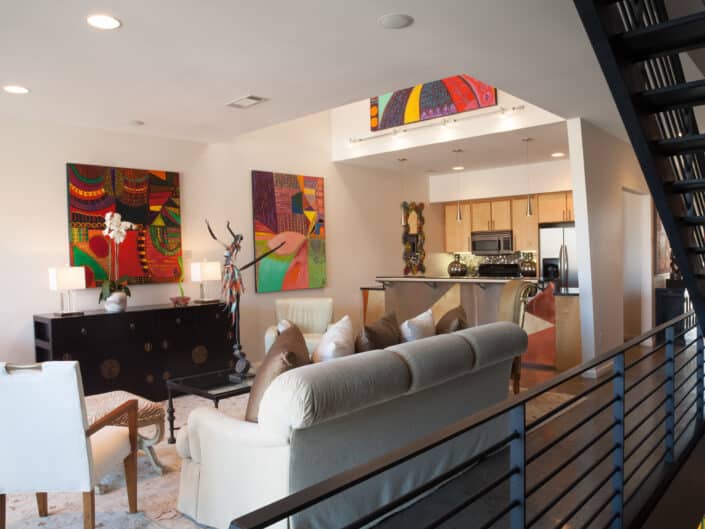 Chic and modern living area with colorful art pieces and an open concept kitchen
