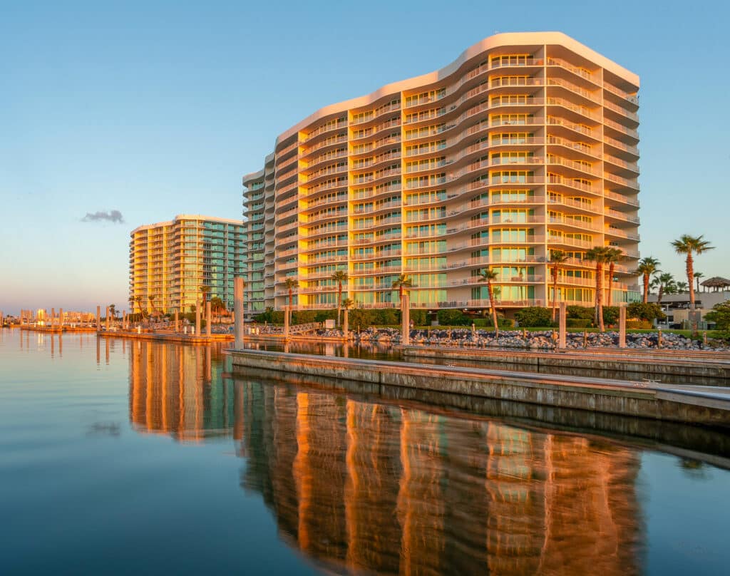 Sunset view of luxury waterfront condominiums at Perdido Key, Florida, with calm reflective waters