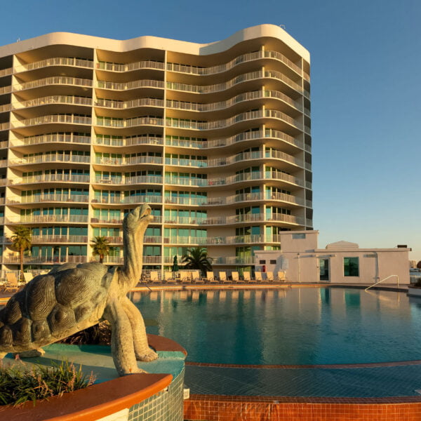 Golden hour at a luxurious condominium complex with a turtle sculpture beside the sparkling pool