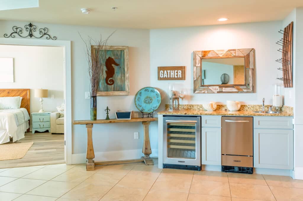 Coastal-themed kitchenette with modern amenities, wine cooler, and decorative seahorse art