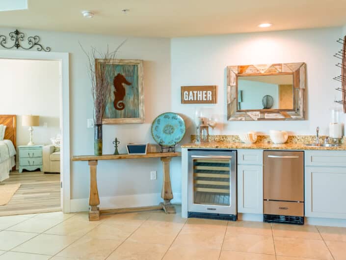 Coastal-themed kitchenette with modern amenities, wine cooler, and decorative seahorse art